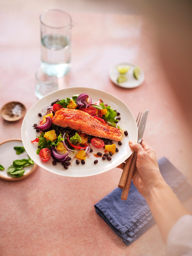 Plated pan-seared salmon fillet served with healthy salad.